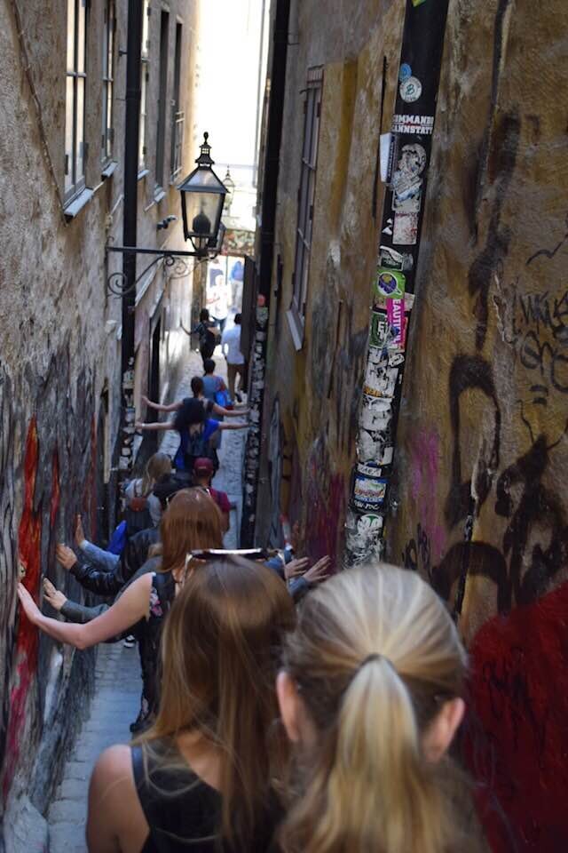 A line of individuals walking through a narrow alley