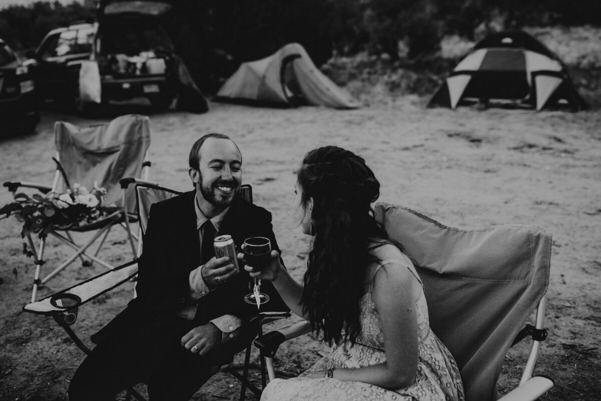 bride and groom toasting at campsite