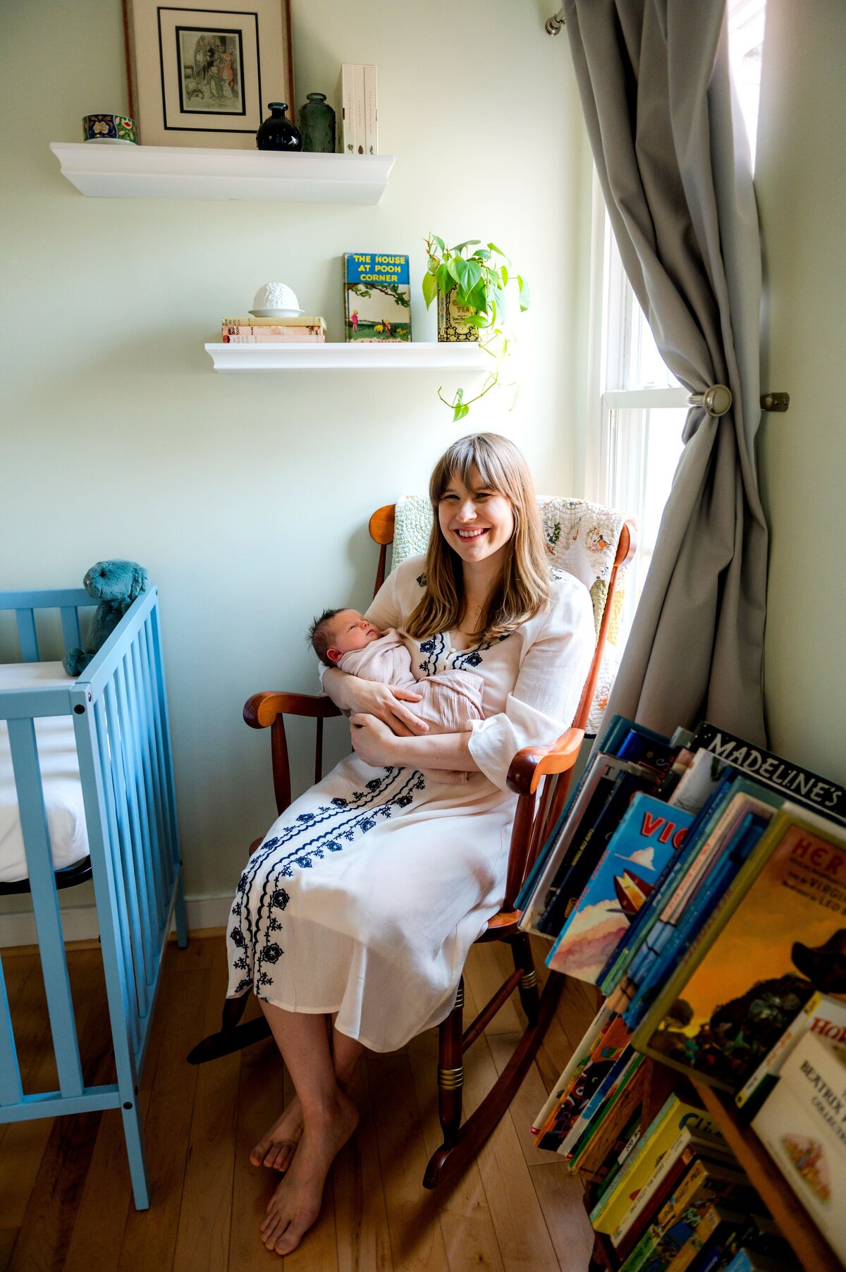 mom in nursery rocking chair singing baby to sleep