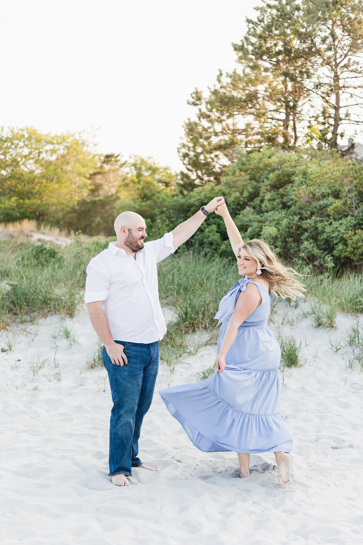 An engaged couple dances on the beach in Gloucster, MA