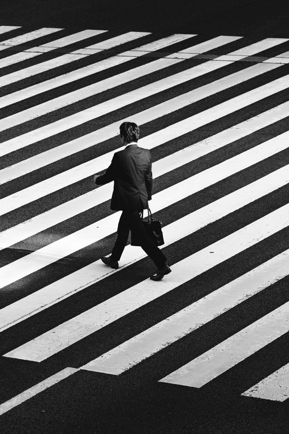 Business man walking across the road