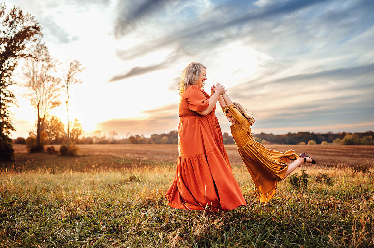 Bowling Green Kentucky family photographer. Mom swinging daughter around in circles.