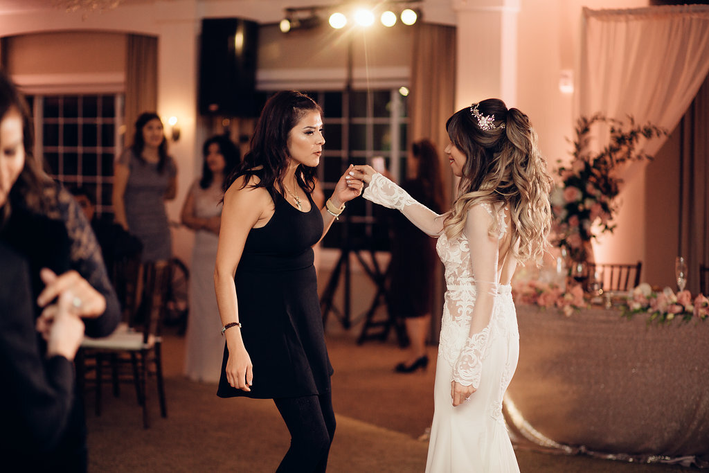 Wedding Photograph Of Bride Dancing With A Woman In Black Jumpsuit Los Angeles