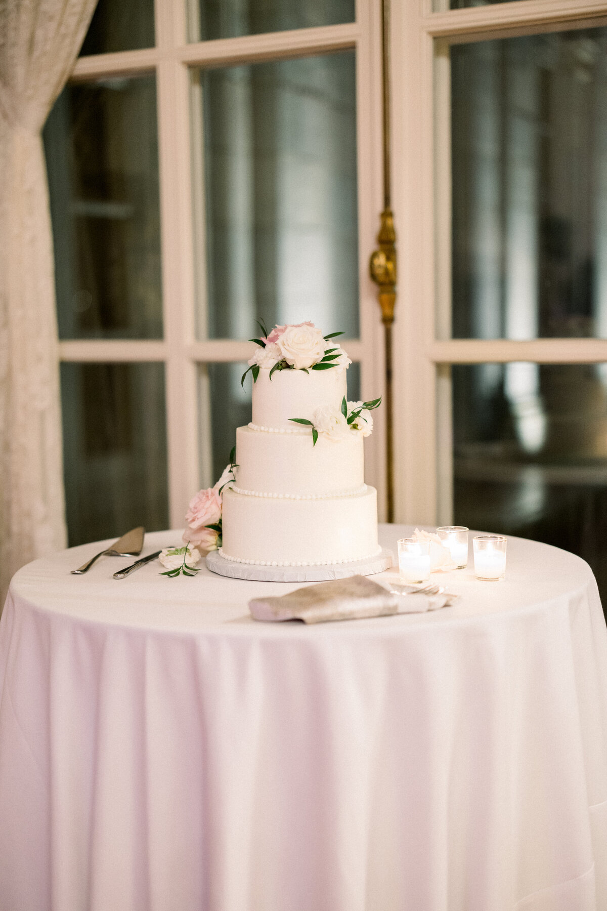 3 tier white wedding cake with florals  at rosecliff mansion