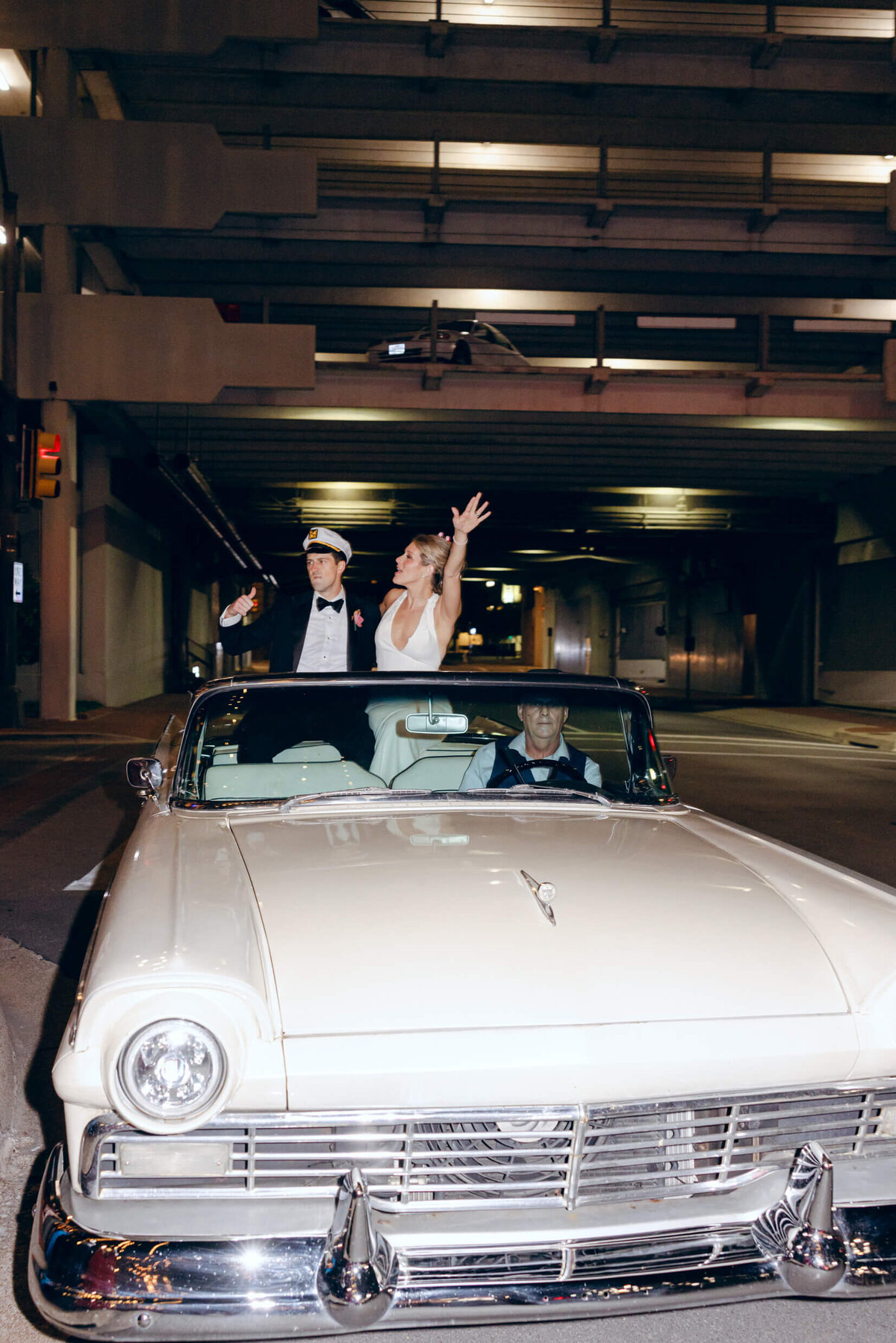 A wedding photo of the bride and groom in their getaway car in Forth Worth Texas