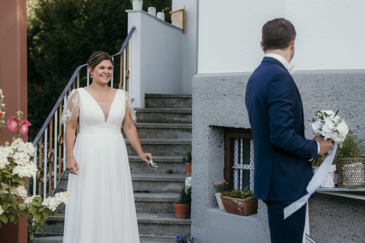 Sichtlich aufgeregt kommt die Braut beim First Look auf den Bräutigam zu, der sich umdreht.