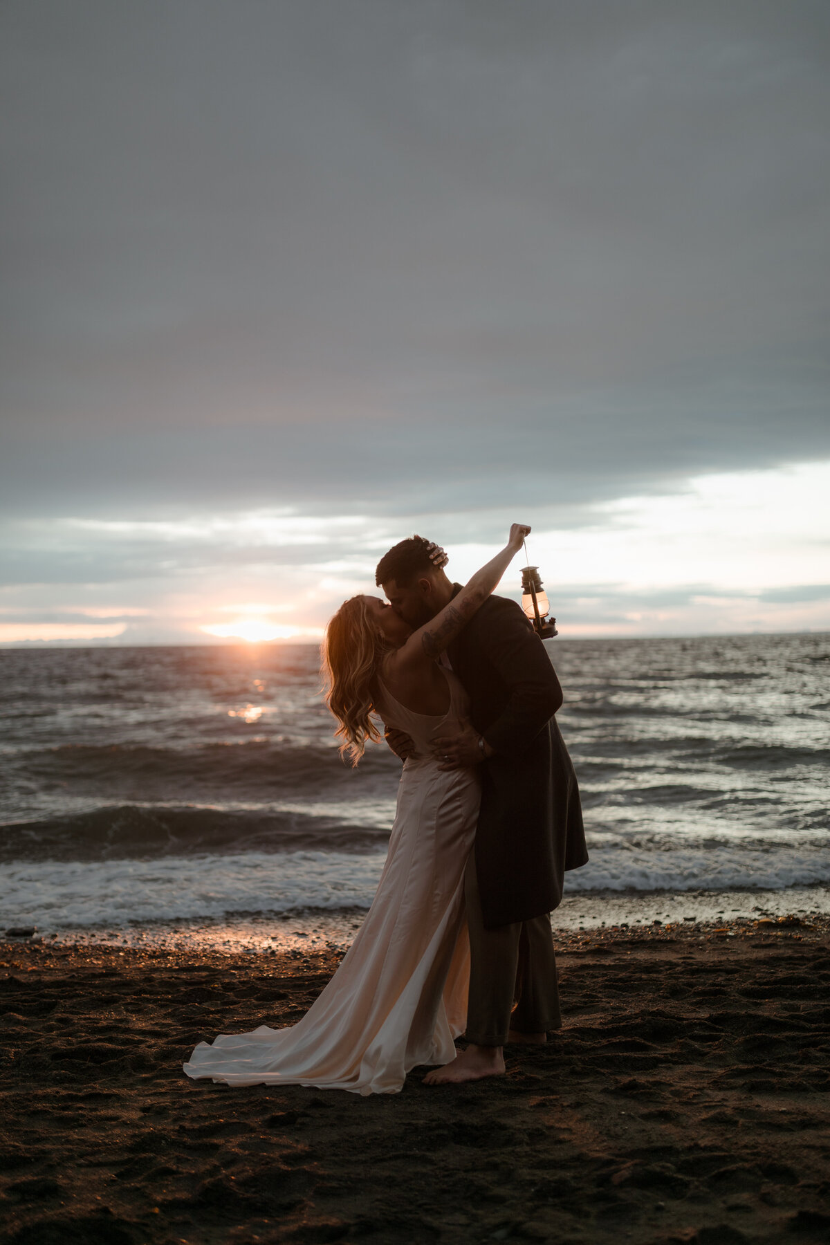 bride and groom kissing on beach