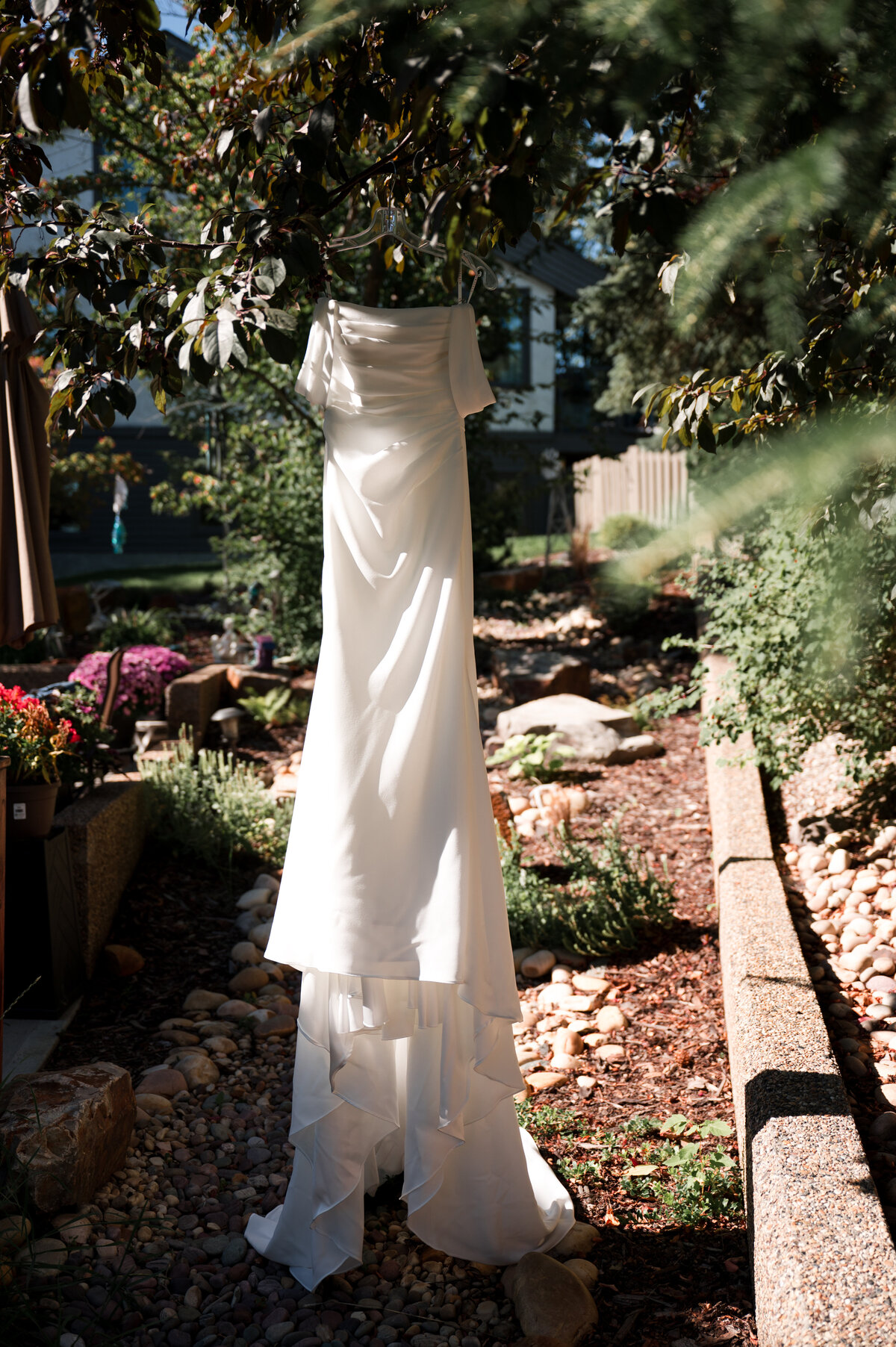 wedding dress haging from a tree on sunny wedding morning