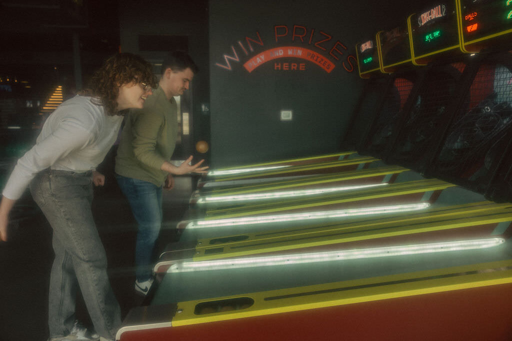 A couple playing ski ball.