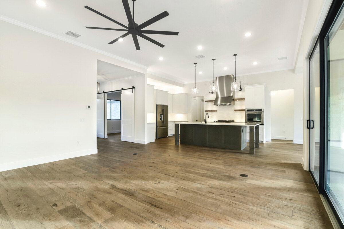 black kitchen island open to living room with wood floors