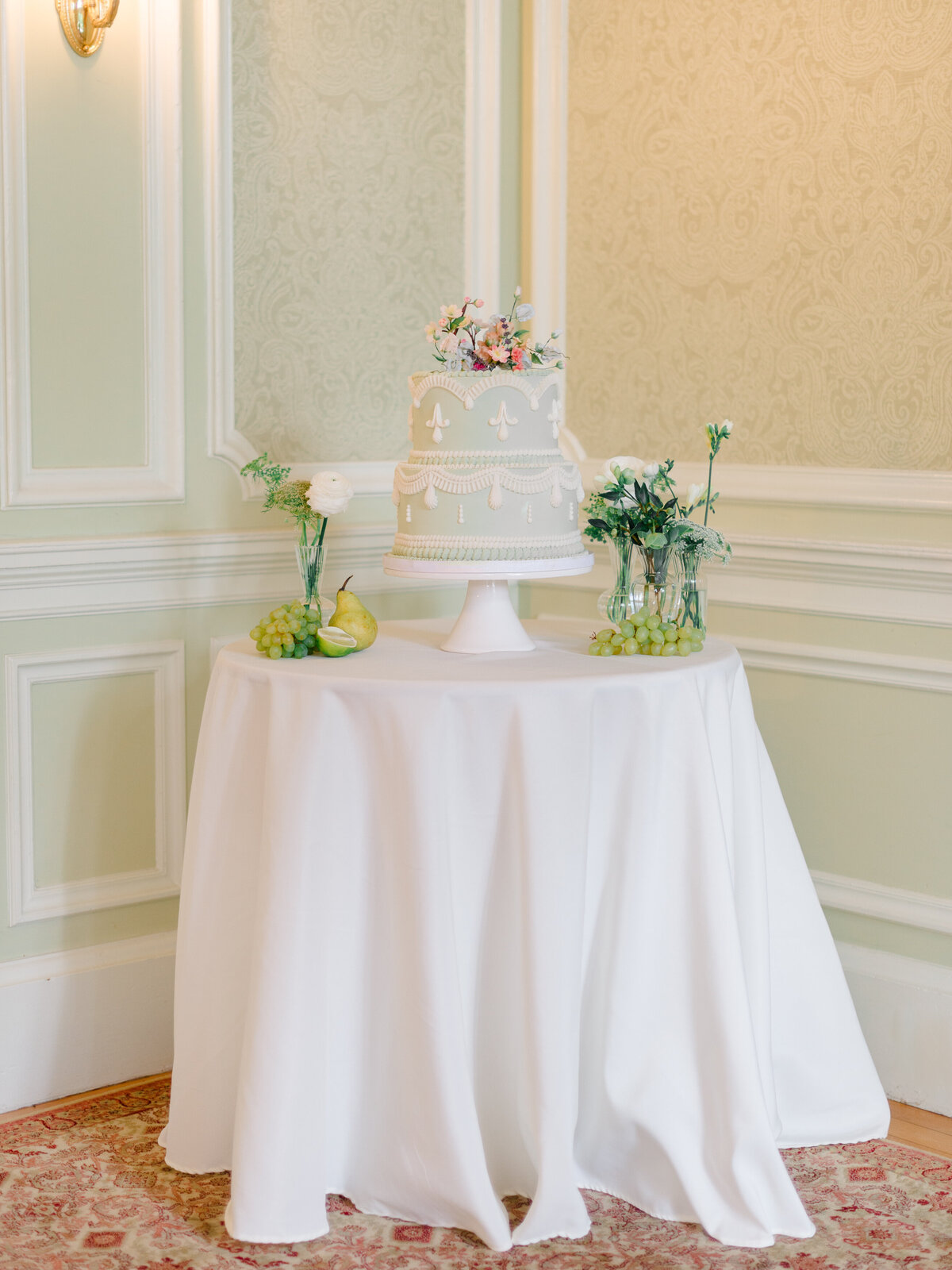Regency-inspired wedding cake display at Cairnwood Estate, styled with delicate piped details, fresh florals, and heirloom fruits. Captured by Philadelphia Fine Art Wedding Photographer Elizabeth Kane, this timeless vignette reflects the elegance and grandeur of a luxury East Coast wedding celebration.