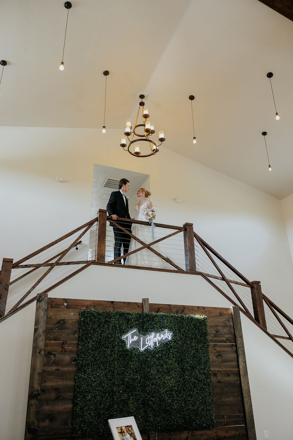 Couple on the upstairs walkway above the greenery wall