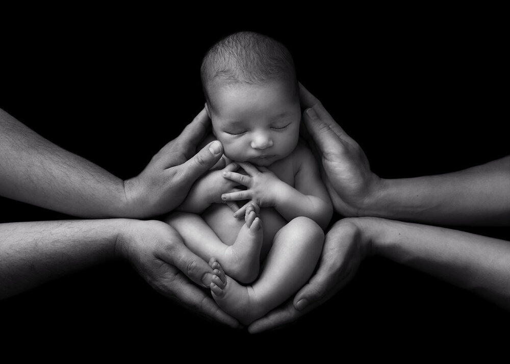NEWBORN_BABYINPARENTSHANDSBLACKANDWHITE