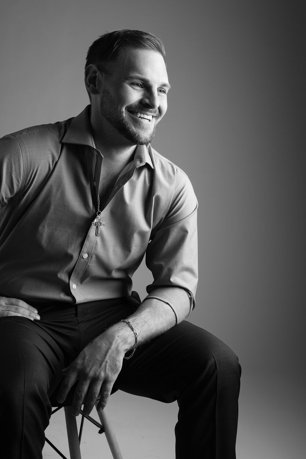 Professional portrait of a confident man photographed in a clean, modern studio environment.