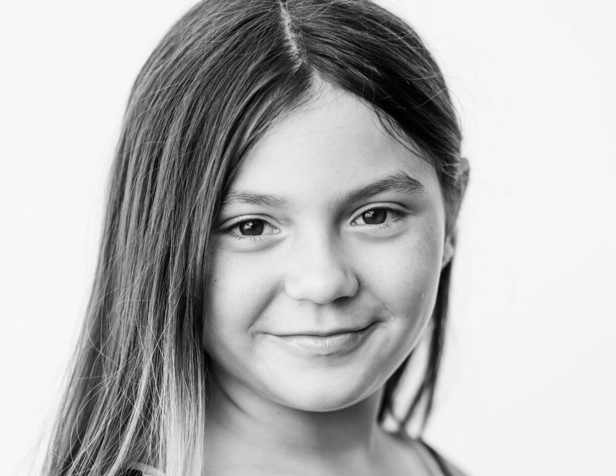 Fine art image of 5th-grade girl with white backdrop and airy lighting