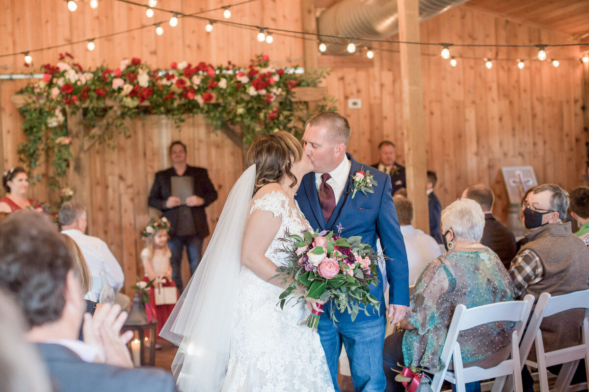 The bride & groom stop to kiss during the recessional. Photographed by Colorado wedding photographer Stephanie Eddy