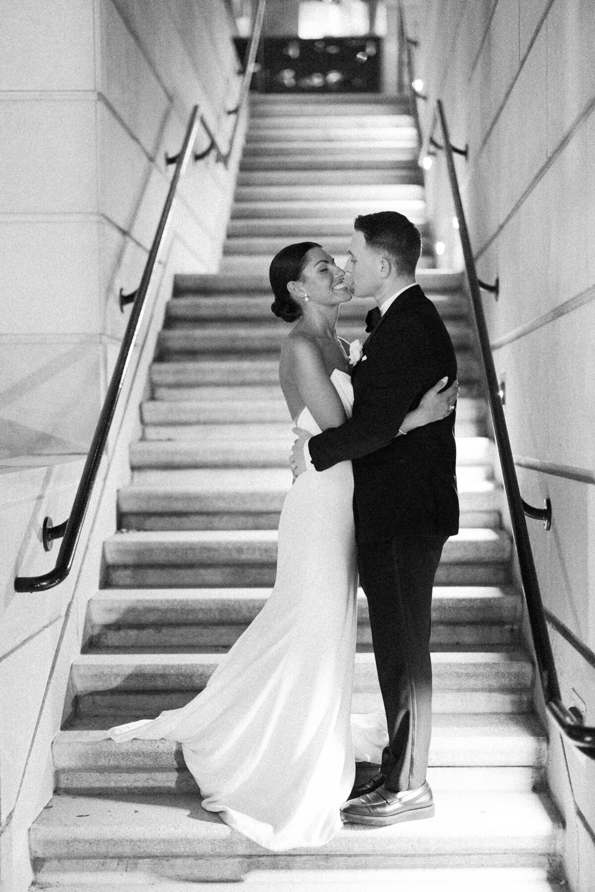A dramatic black and white wedding portrait of a couple standing together at night outside RPM Events, exuding classic romance.