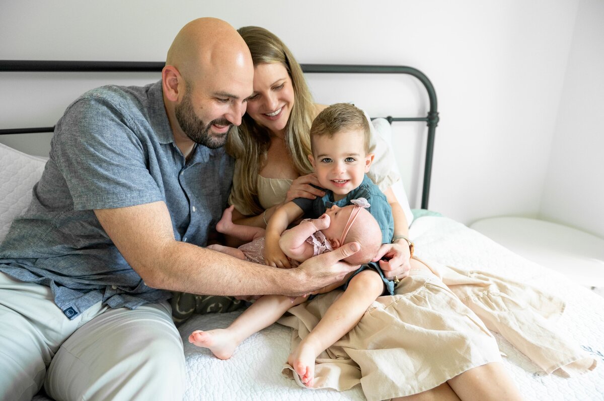 baby boy lookng and smiling at camera with his newborn sister
