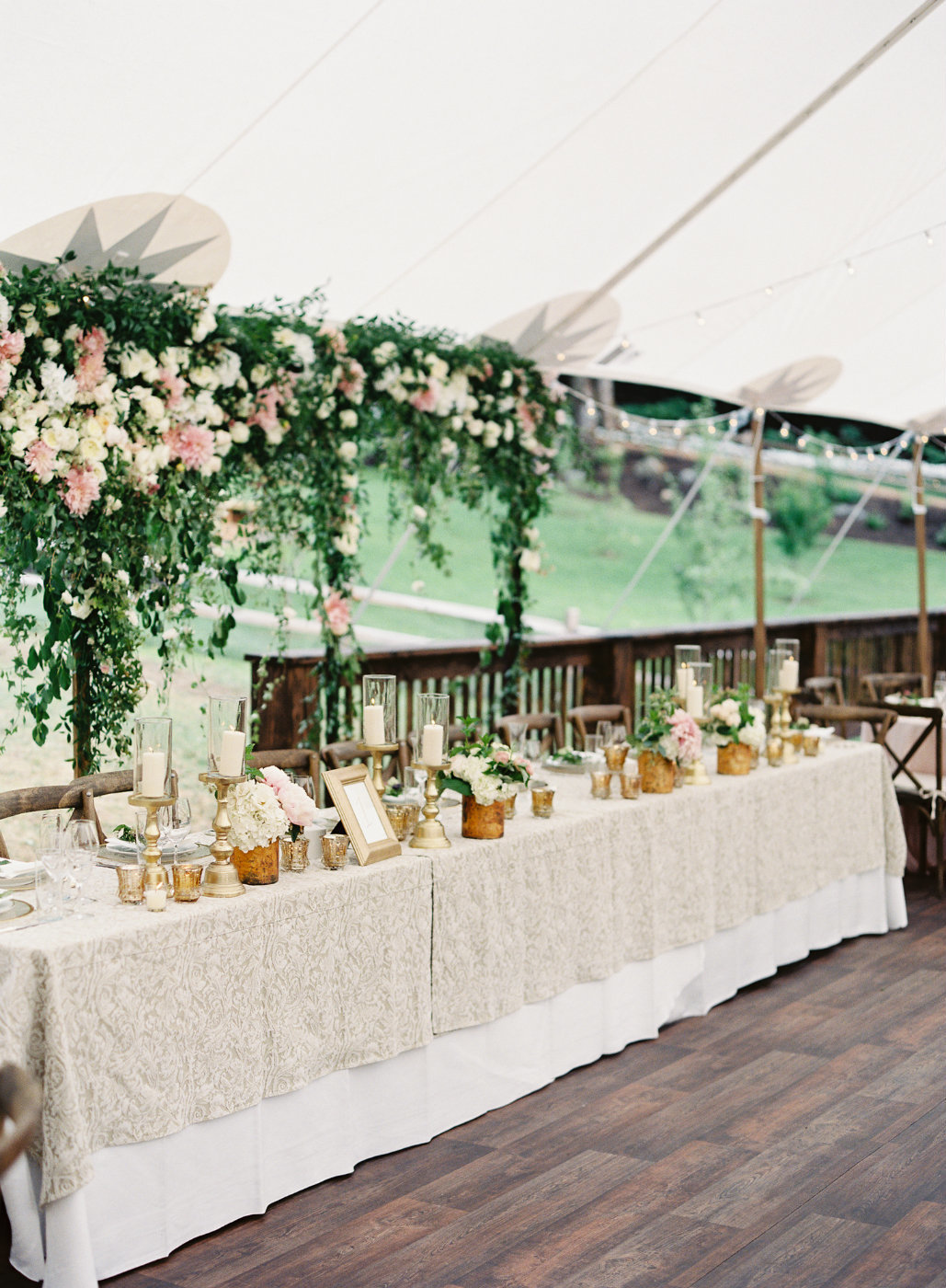 Luxury blush wedding head table floral backdrop installation.