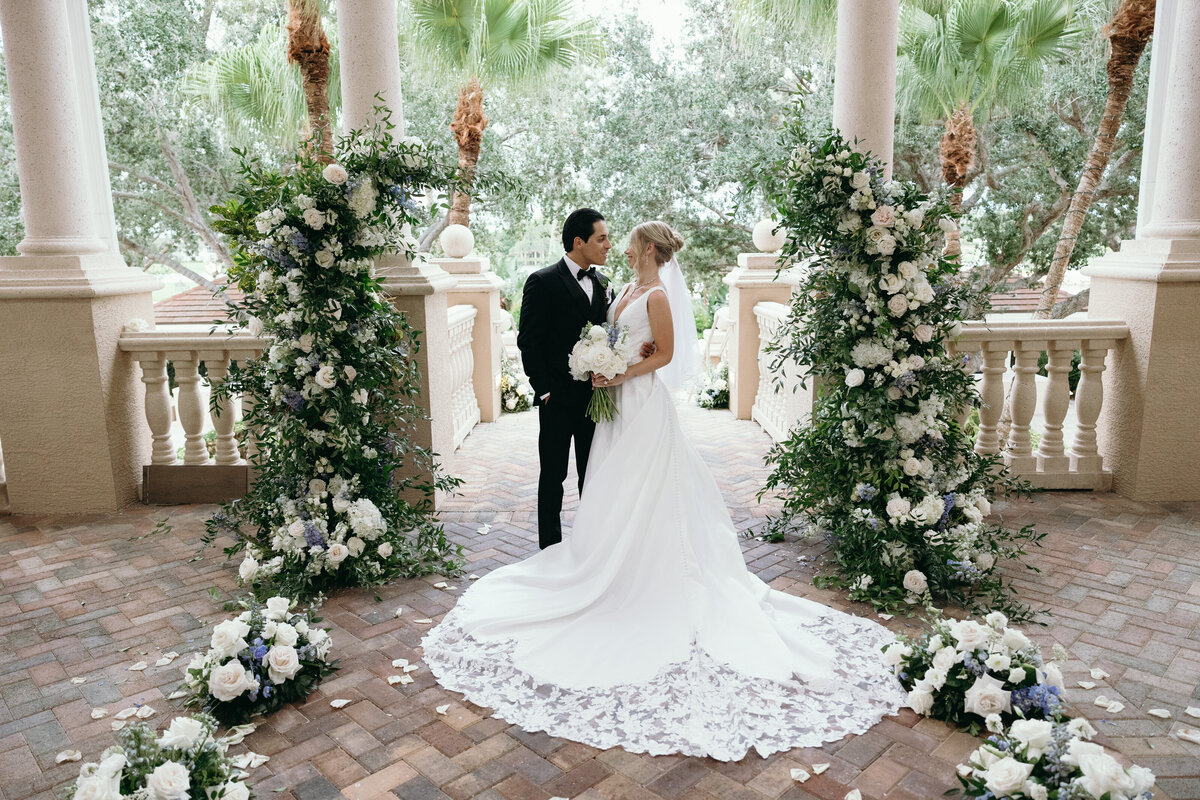 Bride and groom posing for bridal portraits with beautiful florals captured by Naples Wedding Photographer - Priscila Del Cristo Photo