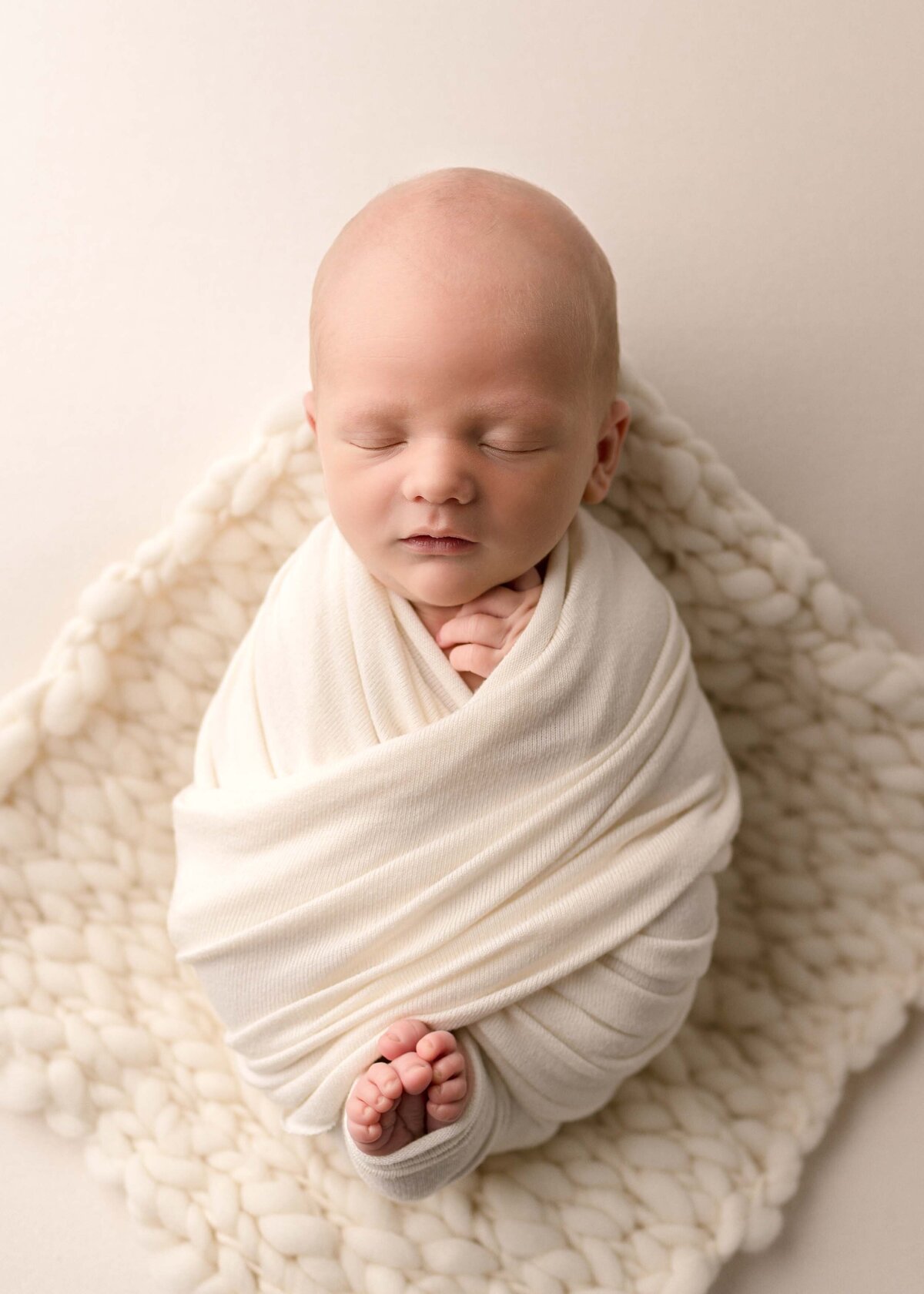 Newborn Swaddled In Cream Blanket
