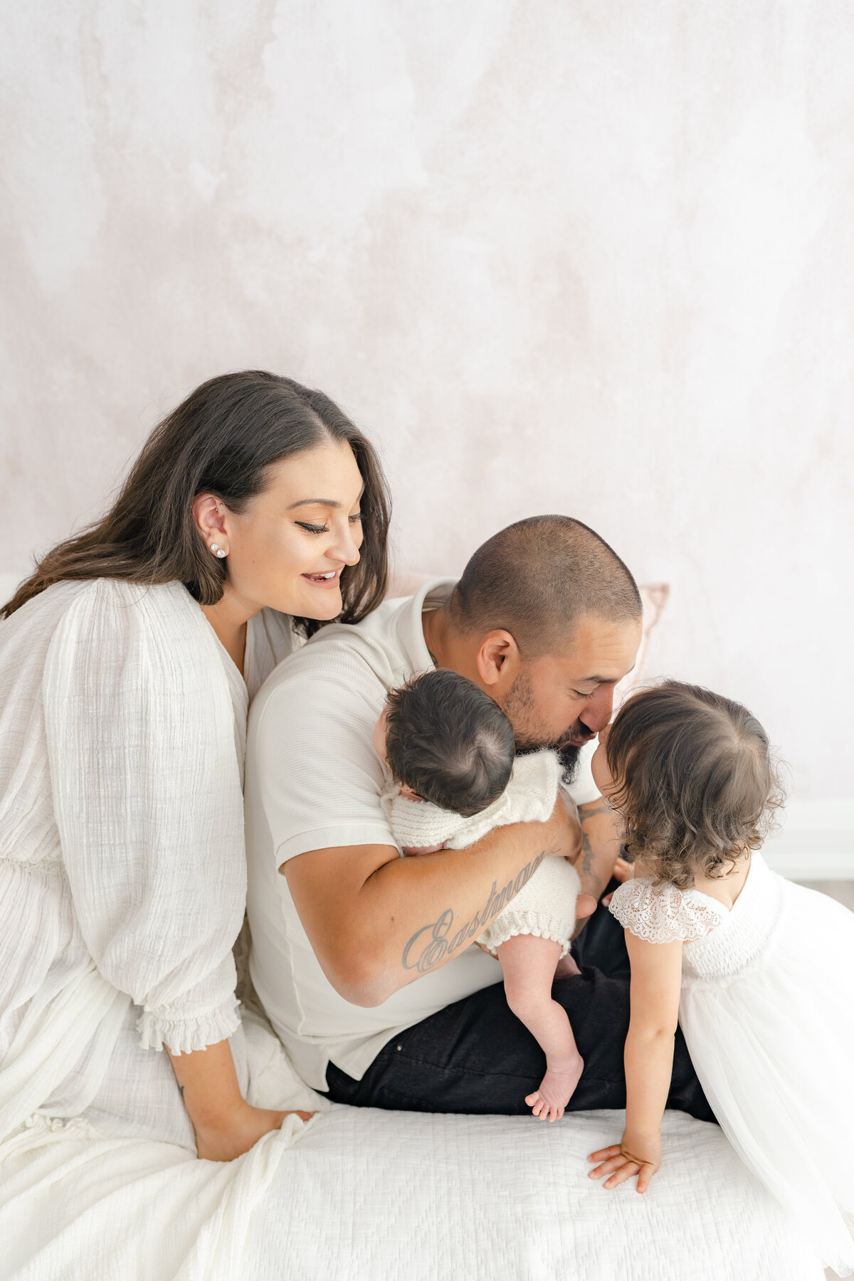 Family cuddling baby during natural light Barrie newborn photography session 