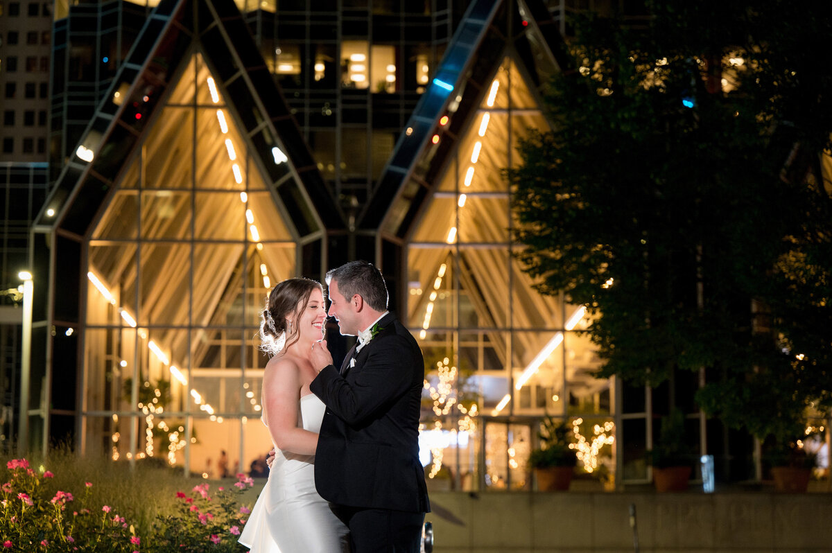 wedding photo with a couple standing in front of wintergarden at ppg place at night