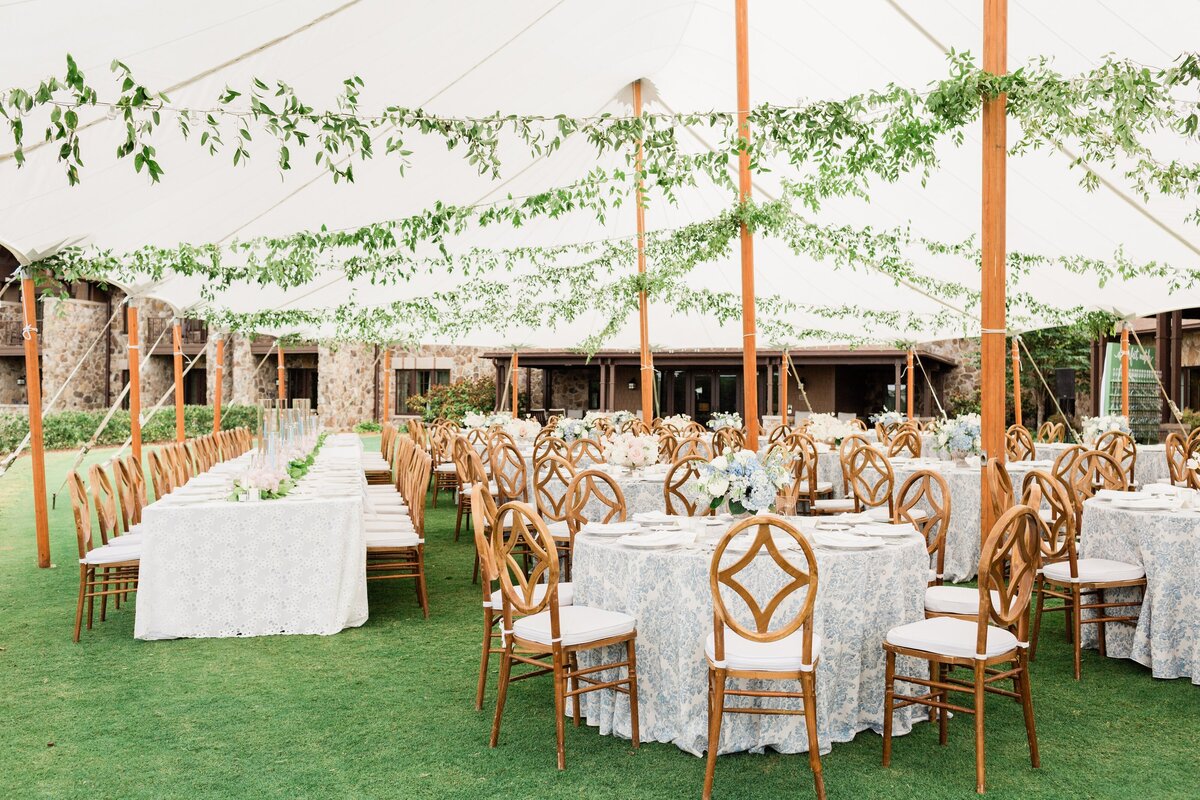 Hanging greenery in a wedding tent sail cloth tent wood chairs