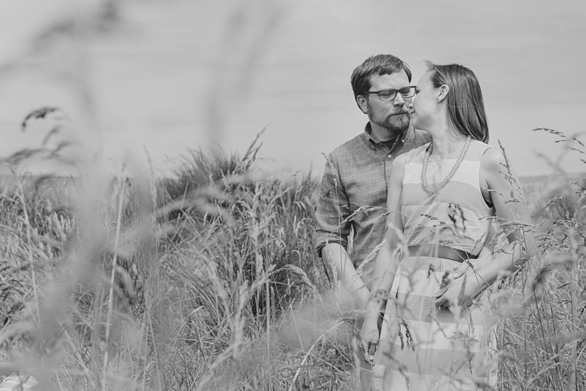 A couple about to kiss while standing in an overgrown field