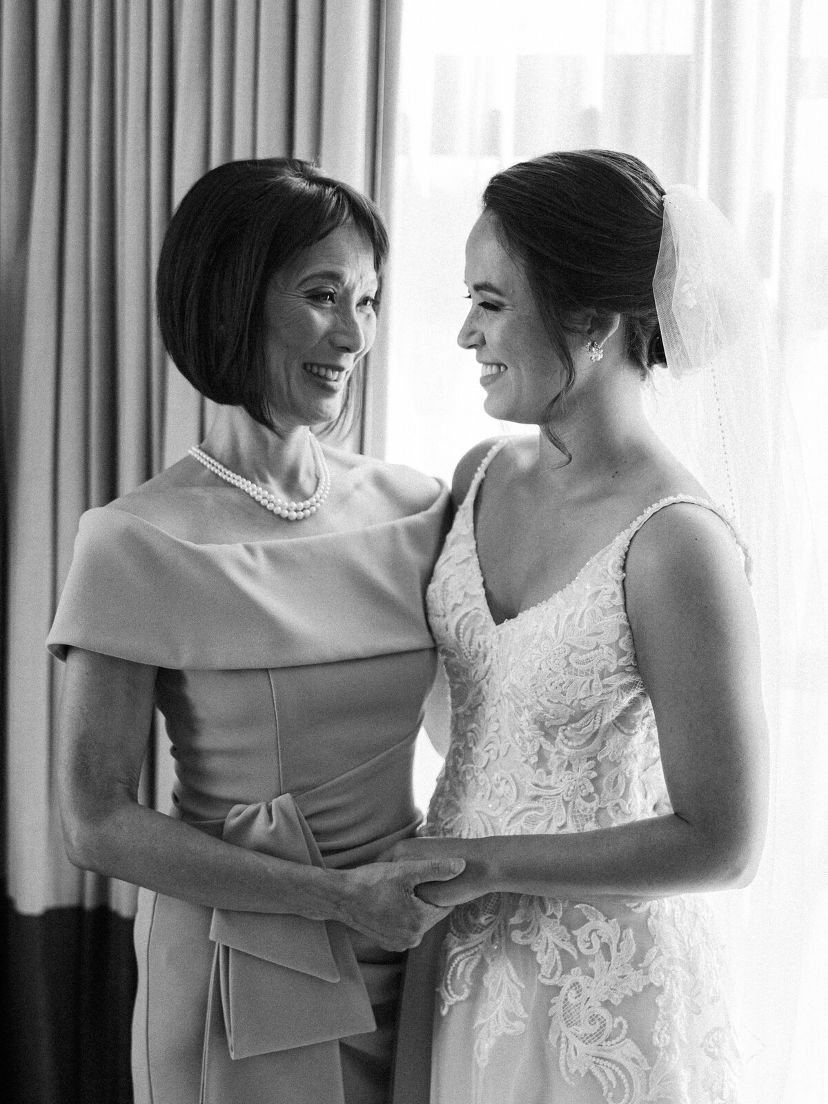 A bride and her mom share a touching moment while the bride gets ready for her wedding