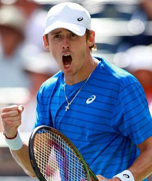 Professional tennis player celebrating with a fist pump during a United Cup match, wearing a blue shirt and white cap