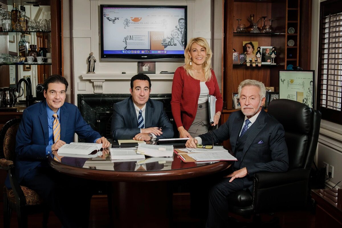 Professional corporate headshot of business executives in suits seated at office desk during meeting new jersey.