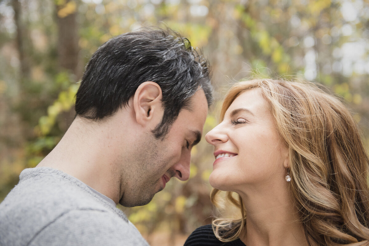 A couple laughing as they stand closely together