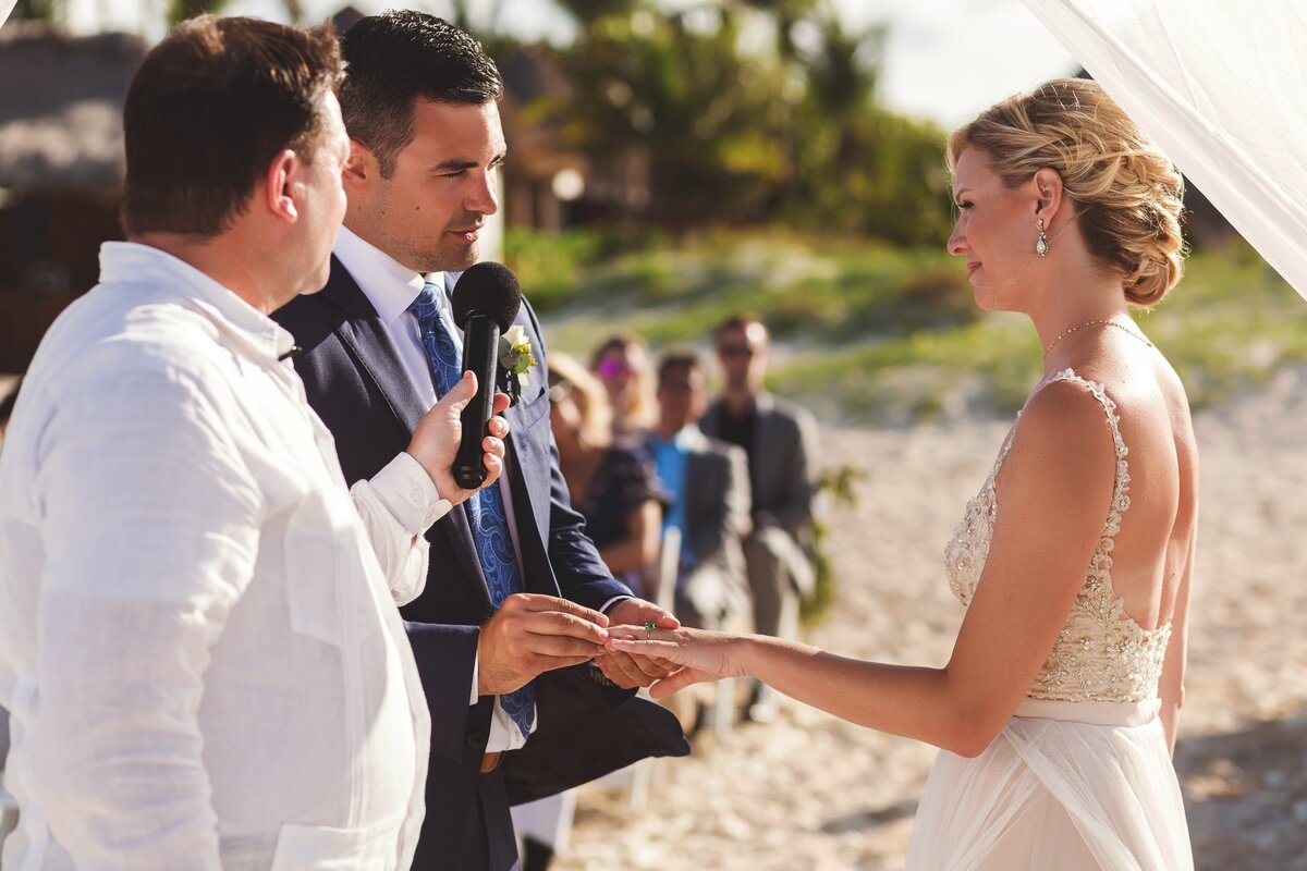 Groom putting ring on brie at wedding in Cancun
