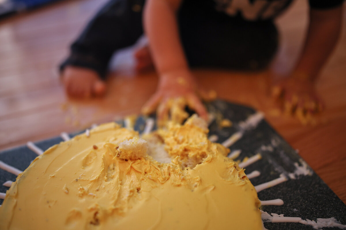 baby boy smashing yellow birthday cake