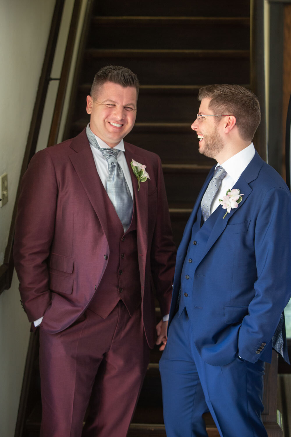 Two men in suits are standing next to each other and smiling
