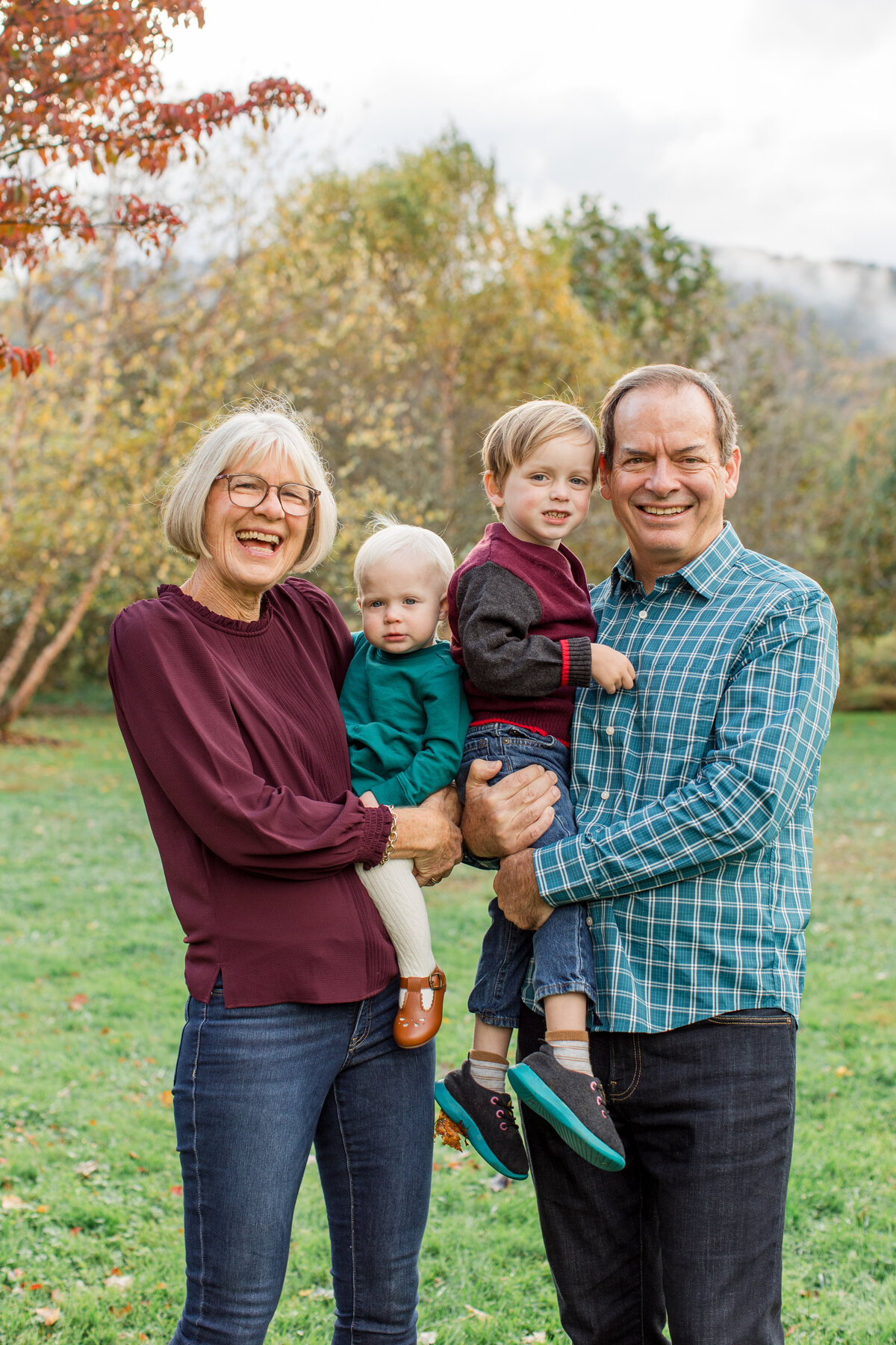 Extended Family session in Boone, NC photo of a grandfather and grandmother holding their two grandchildren.