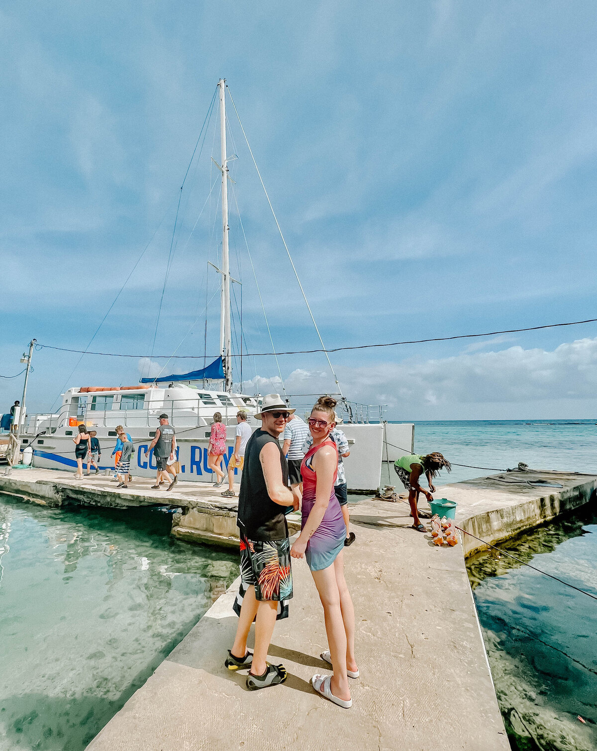 a newly married couple by a boat in Jamaica