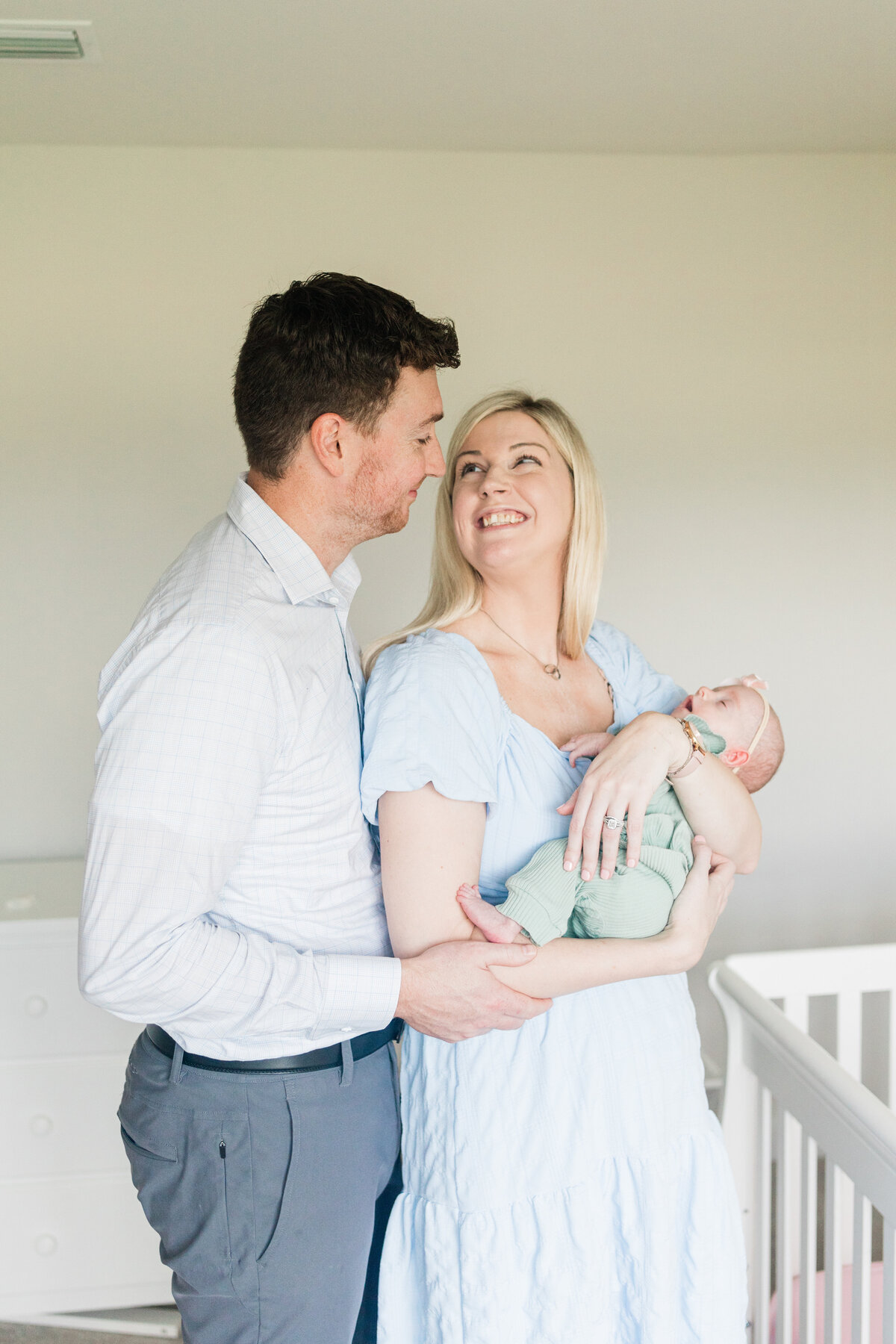 New parents snuggling with newborn daughter