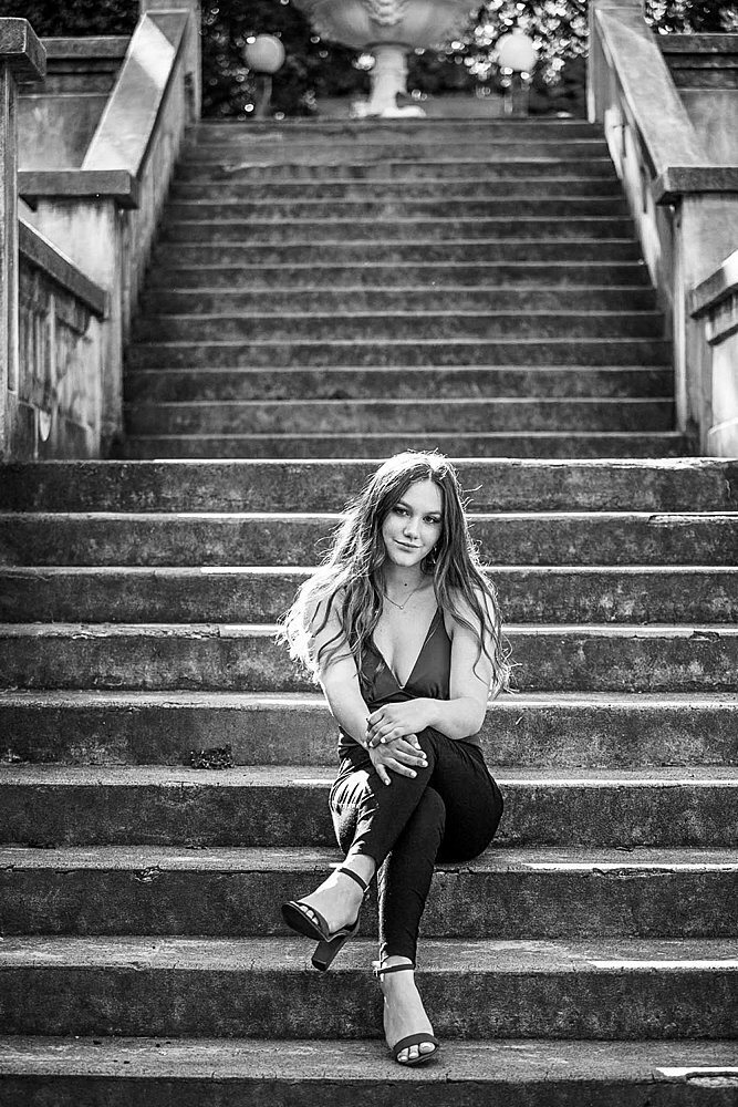 Senior girl in high heels sitting on stone steps in Ashland