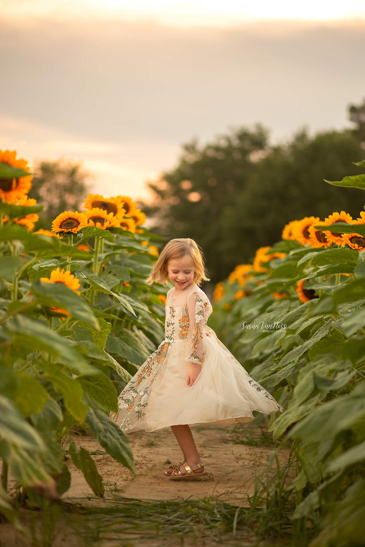 Girl spinning in a sunflower field enjoying her children's photography