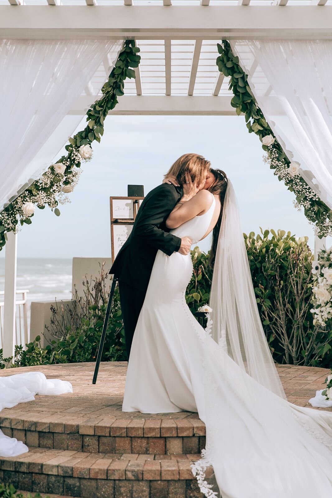 bride and grooms first kiss at the alter at the shores resort