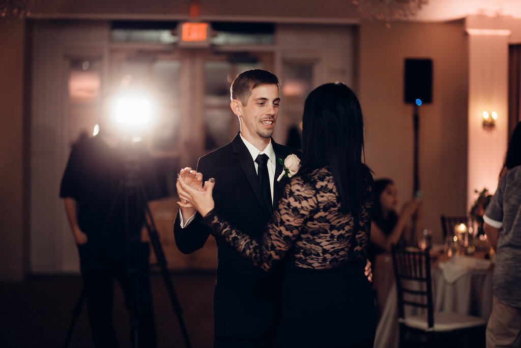 Wedding Photograph Of Man In Black Suit Dancing With A Woman In Black Dress Los Angeles