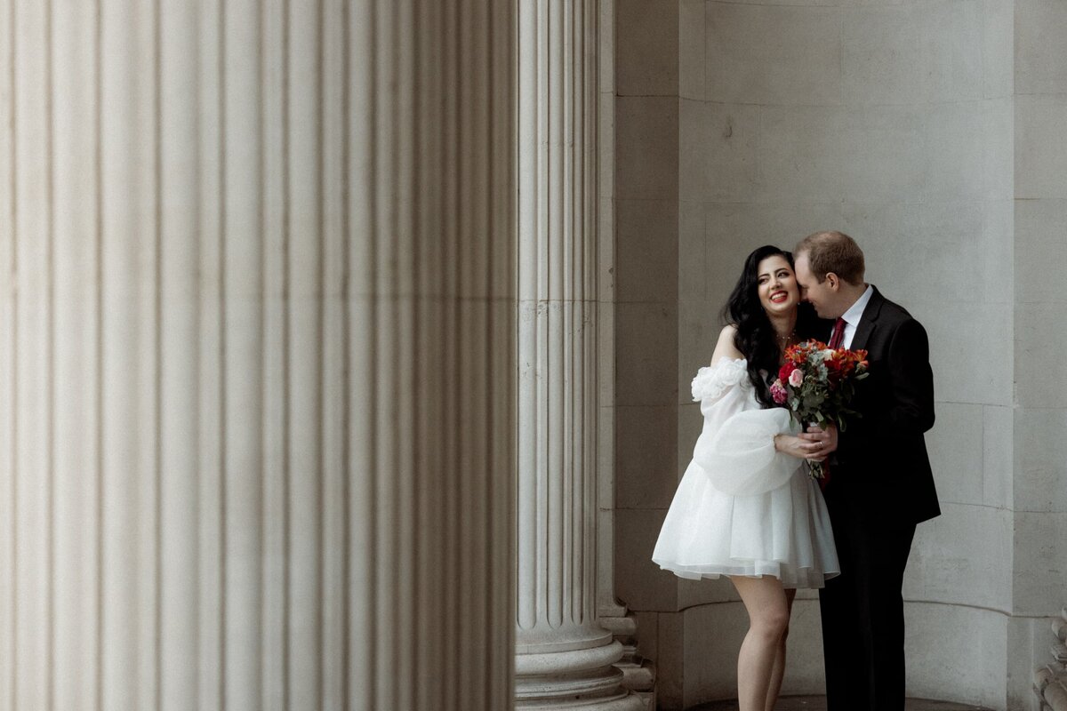 Candid moment couple kissing and gigetting after getting  married at Old Marylebone town hall in London
