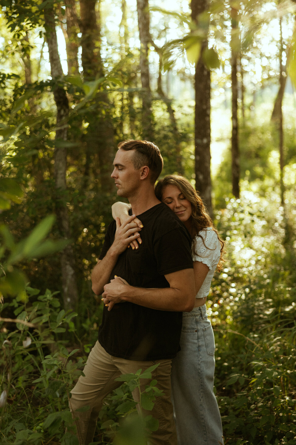 Couple posing for portraits in a forest.