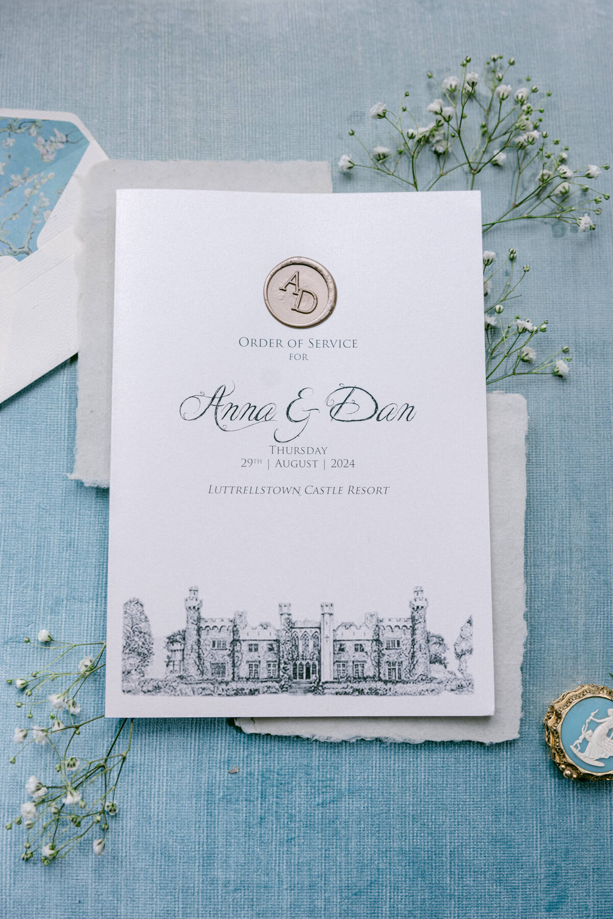 A wedding day picture of the couples invitations whihc has a drawing of the venue Luttrellstown Castle on it