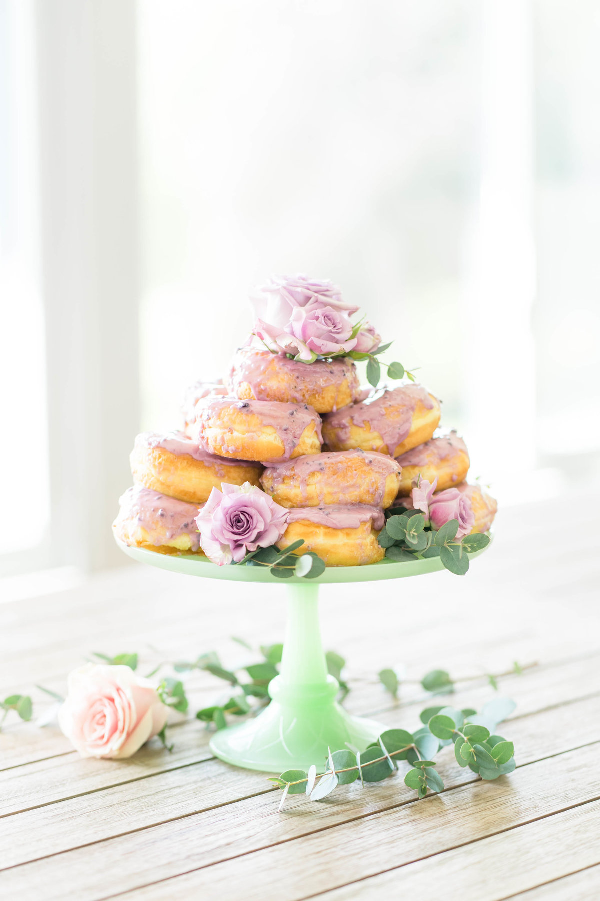Donuts on green stand with pink roses