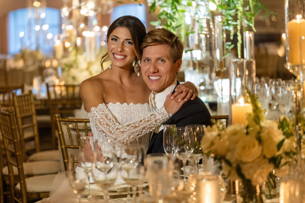 A bride and groom are posing for a picture at their wedding reception