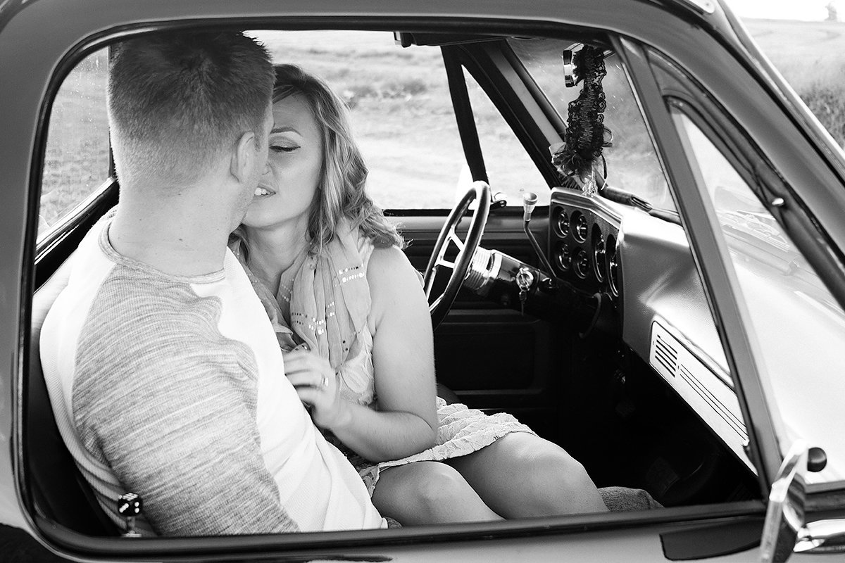 engaged couple kissing in truck
