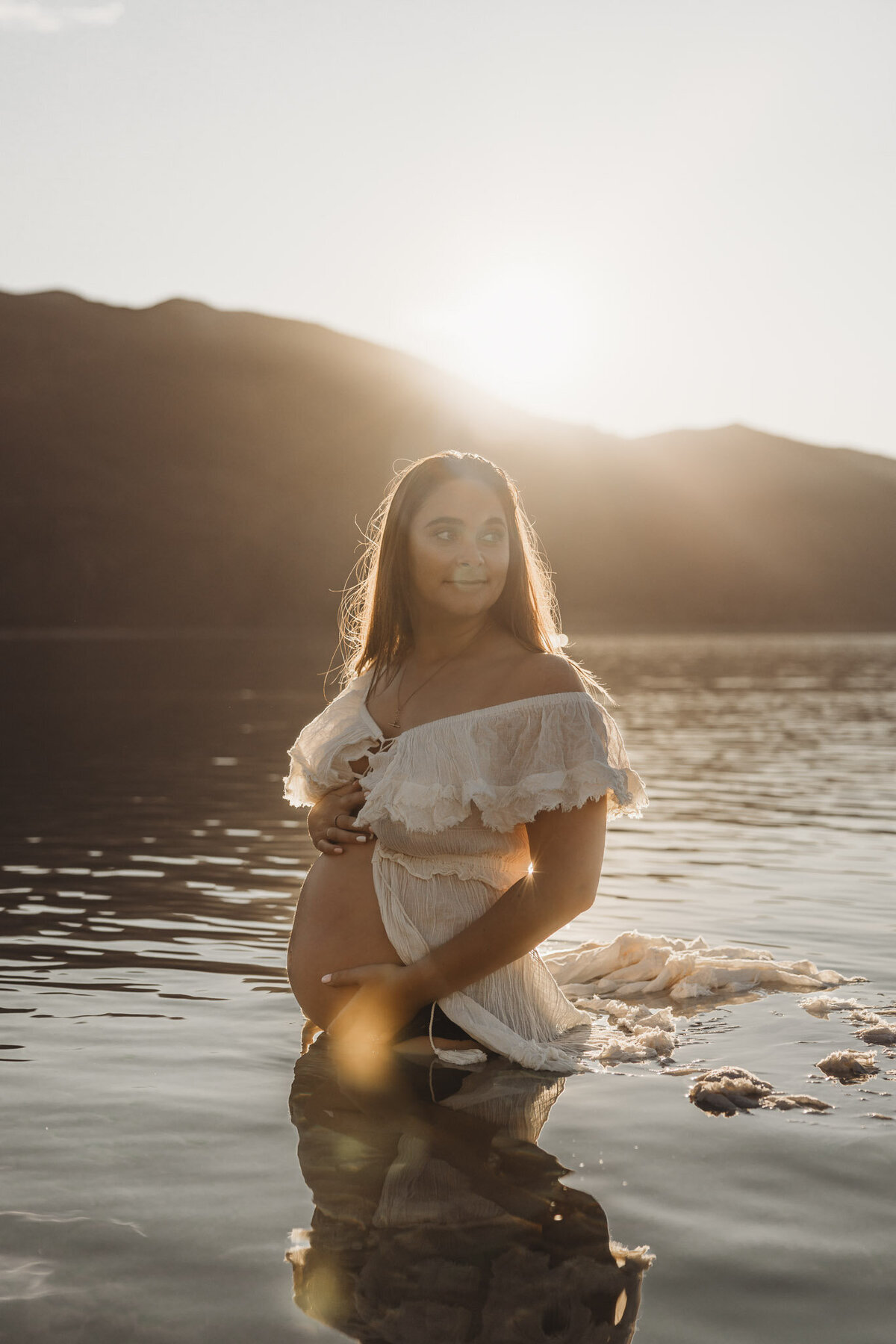 pregnant woman standing in the lake during her maternity session
